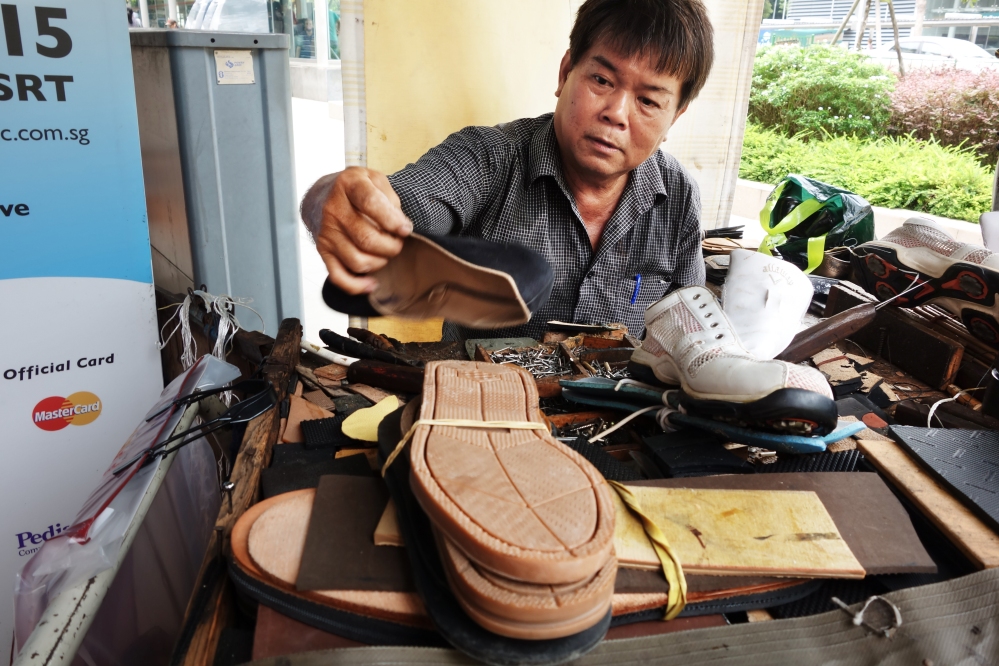 Mr Chia, a cobbler at Holland Village in Singapore, repairing shoes | ShopkeeperStories.com
