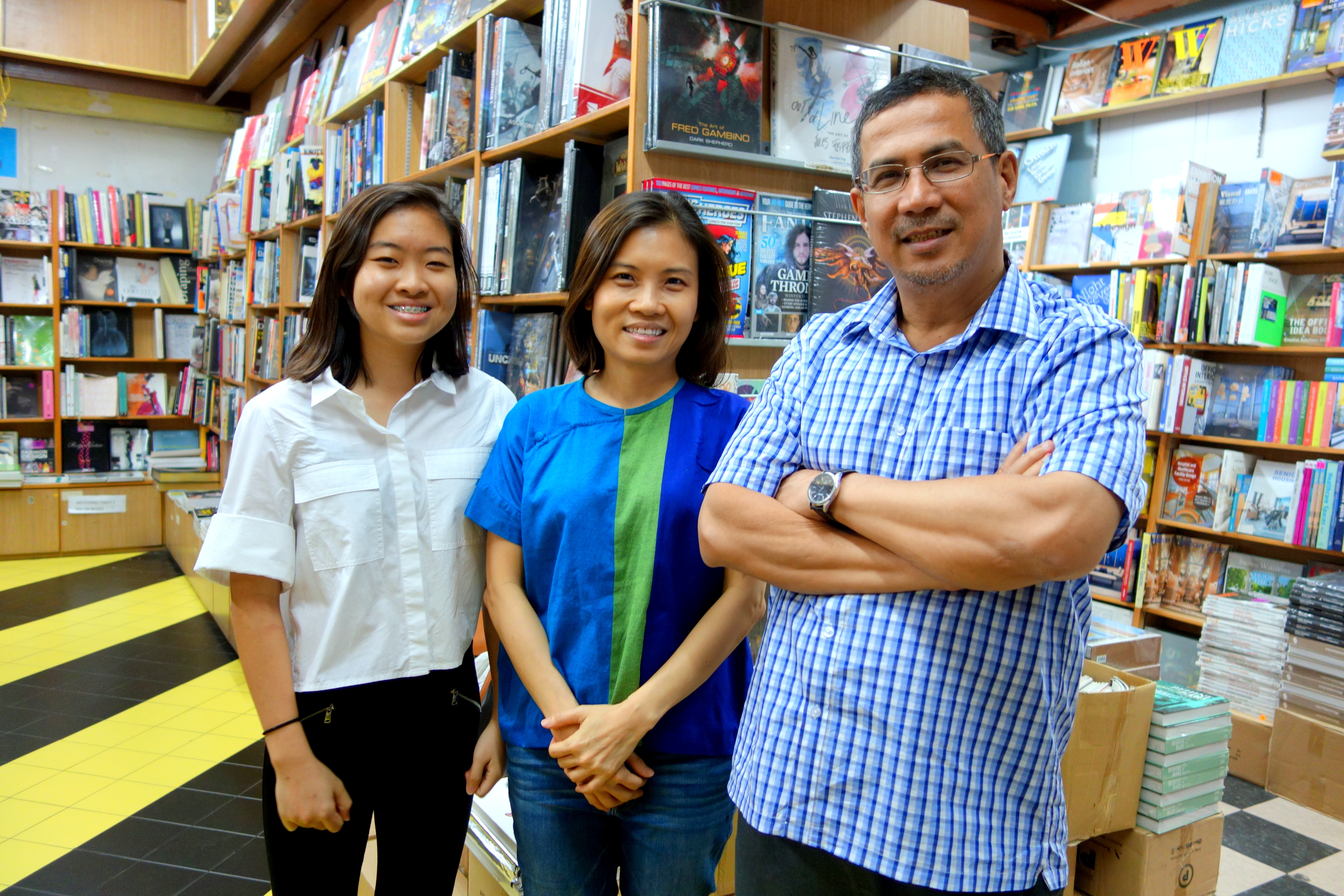 Basheer Graphic Books with the owner Abdul Nasser and his customer Dawn Liang at Bras Basah Shopping Complex in Singapore - a bookshop series by Shopkeeper Stories